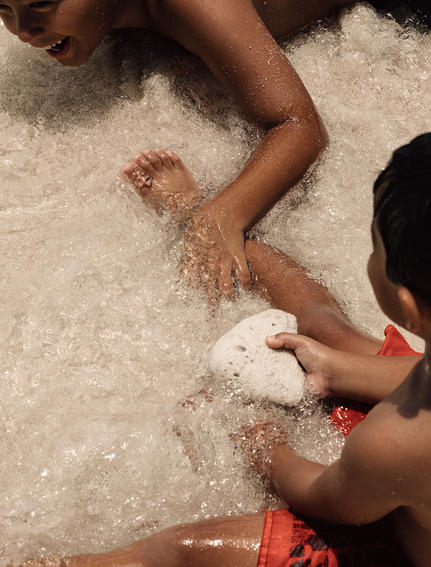 Family members playing in white sand at Aman Villas at Nusa Dua.
