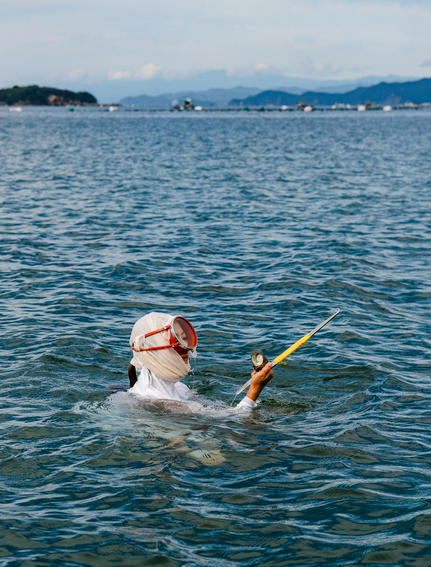 Hotel guest swimming in the calm bay at Amanemu resort.