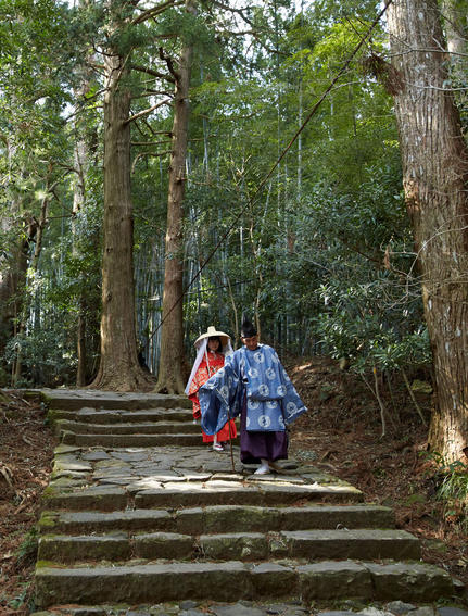 Two guests walking along stone steps through a forested pathway at Amanemu.
