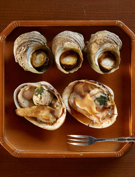 Cinq huîtres fraîches servies dans un plateau en bois à Amanemu, resort côtier japonais.