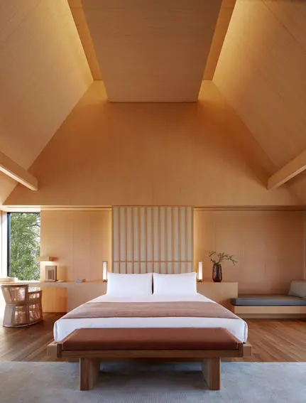 Principal bedroom at Amanemu resort with warm wooden finishes and natural light from skylights.