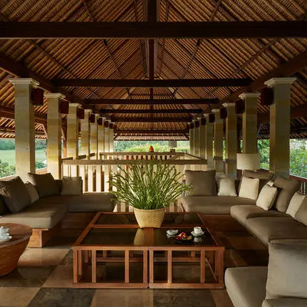 Six-bedroom villa living pavilion at Aman Villas at Nusa Dua, Bali, with wooden beams and stone seating.