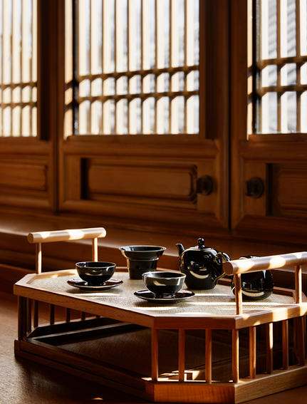 大研安缦度假村内，木制屏风前摆放着传统茶具的茶室一角。