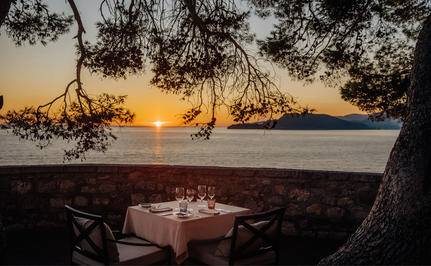 Dining table set at sunset overlooking the Adriatic Sea at Aman Sveti Stefan.