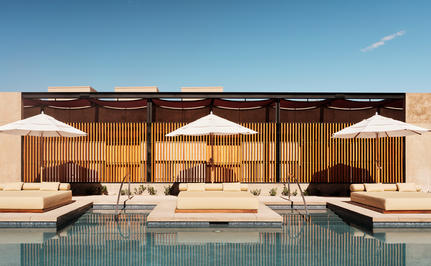 Amangiri wellness pavilion with floor-to-ceiling windows overlooking a plunge pool and desert landscape at dusk.