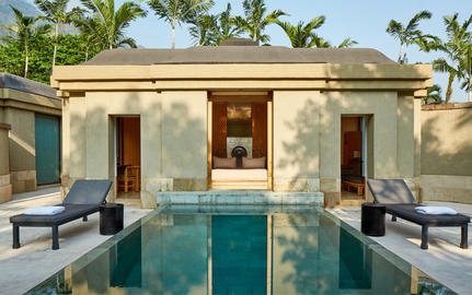 Spa pavilion with plunge pool at Amanjiwo, flanked by loungers beneath palm trees.