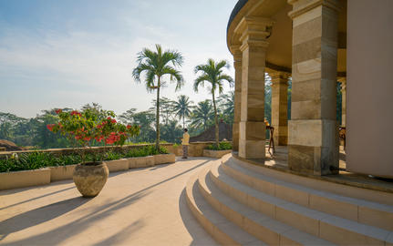 Curved stone terrace with palm trees and valley views at Amanjiwo.