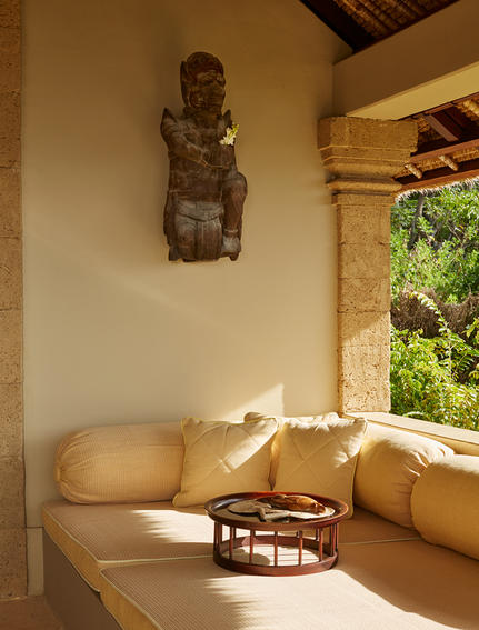 Wooden sculpture displayed above a sunlit spa bath at Amankila resort.