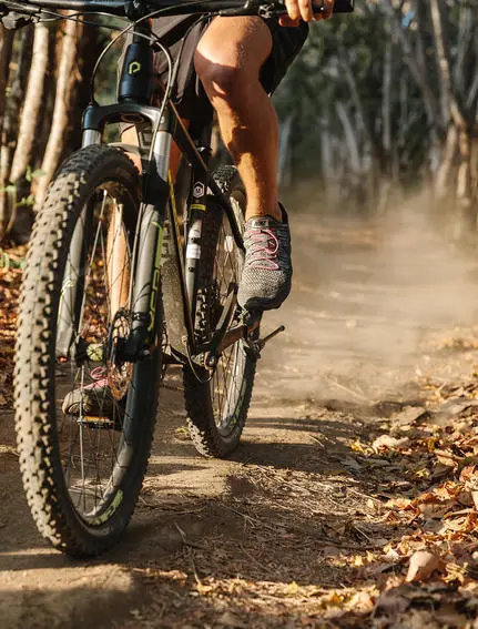 Mountain biker on dusty trail at Amanwana, Indonesia.
