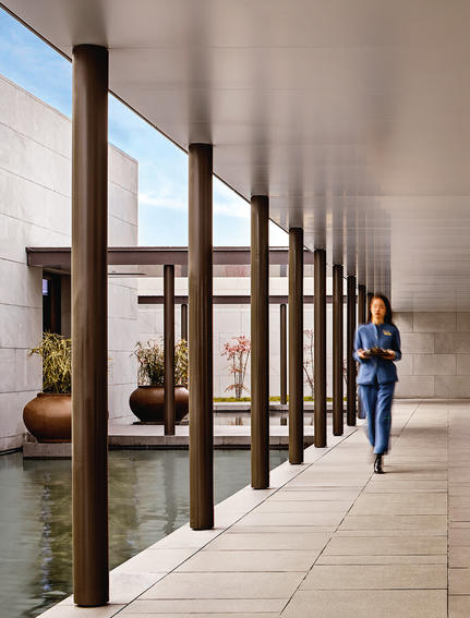 养云安缦度假村的走廊，木质柱子排列成行，自然光线透过大窗洒入。