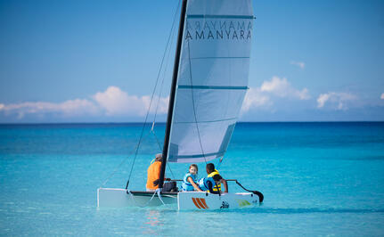 Familia navegando en catamarán en aguas turquesas en Amanyara, centro vacacional.