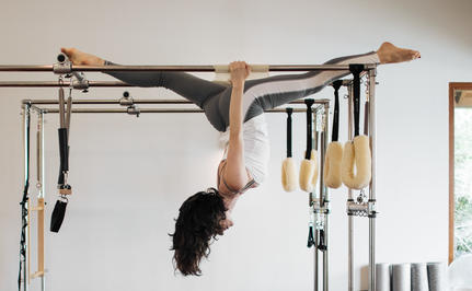 Person practising an inverted exercise on reformer equipment at Amanyara wellness facility.