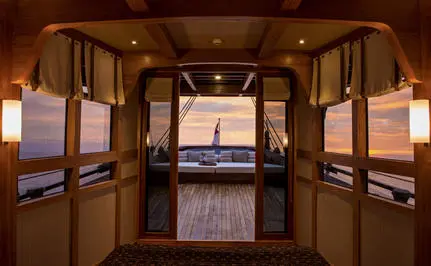 Stern bedroom view at Amandira with open double doors revealing ocean horizon at dusk.