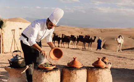 Family activities at Amanjena with adults and children engaging in traditional Moroccan experiences in the desert landscape.