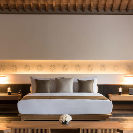 Principal bedroom at Amanoi with upholstered headboard and integrated lighting.
