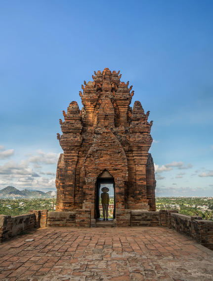 Ancient brick tower at Amanoi with clear blue sky and distant landscape beyond.