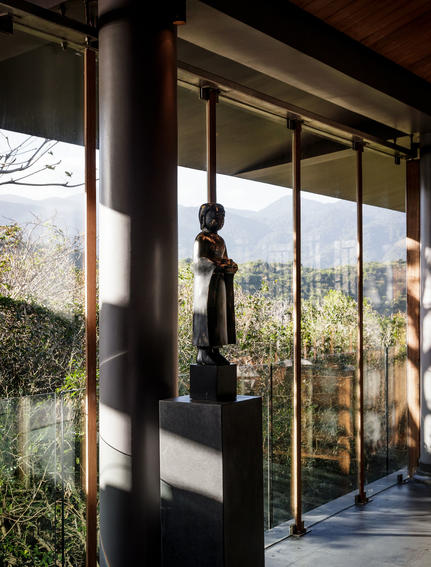 Sunlit pavilion at Amanoi with floor-to-ceiling windows framing verdant landscape views.