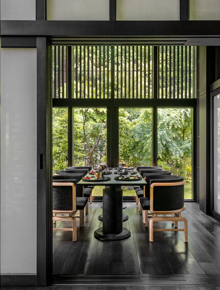 Private dining room at Aman Kyoto with shoji screens and garden views, featuring a low wooden table and seating.