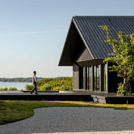 Contemporary black pavilion at Amanemu with water views and manicured gardens.