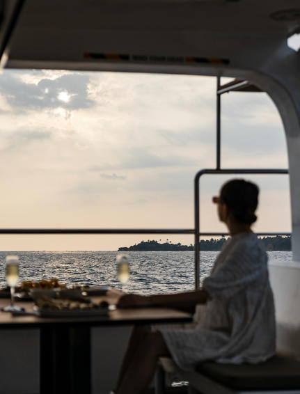 Guest gazing towards coastal views from inside a boat at Amangalla.