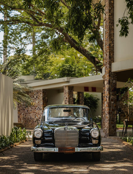 Vintage car parked beneath a shaded pergola at Amansara, Cambodia.