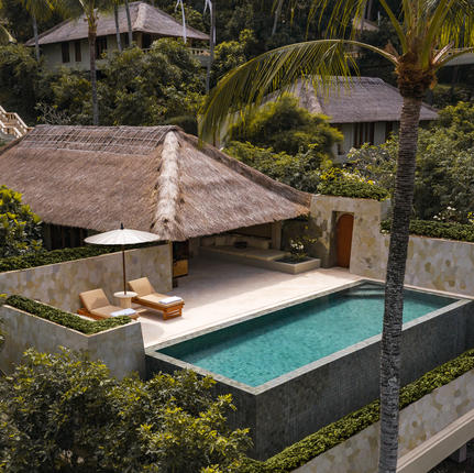 Infinity pool suite with thatched pavilion at Amankila resort, surrounded by tropical gardens.