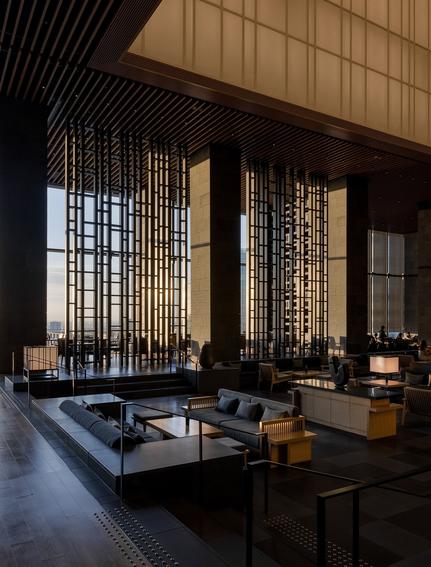 Autumn lounge at Aman Tokyo hotel with geometric screens and minimalist seating arrangement.
