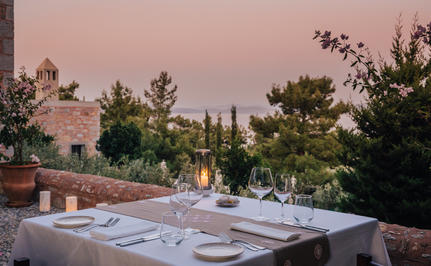 Outdoor dining terrace at Amanruya at dusk, with laid tables overlooking Mediterranean gardens.