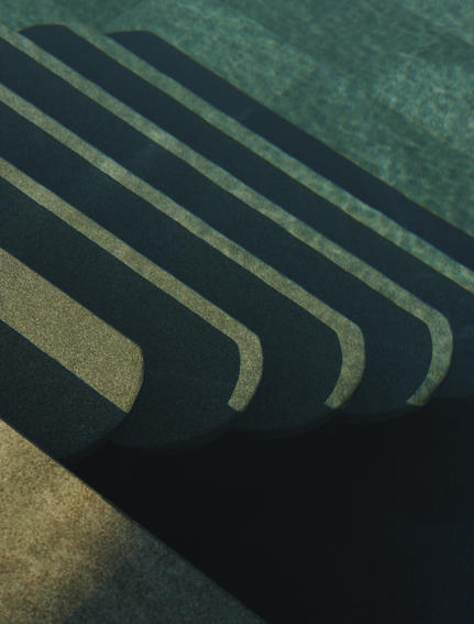 Overhead view of poolside loungers casting geometric shadows at Amanruya, Turkey.