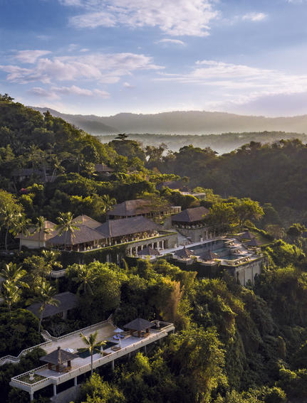Vista aérea de Amankila resort entre colinas boscosas y valle.