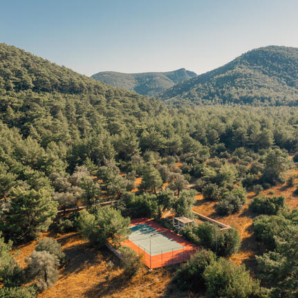 Aerial view of Amanyura tennis court nestled amongst forested hillside.