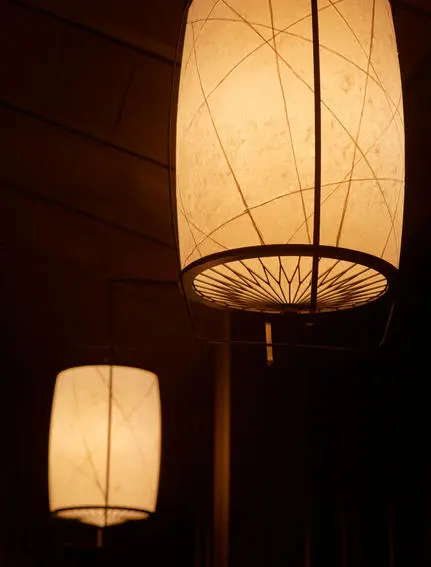 Lanterns illuminated at dusk in the Living Pavilion at Aman Kyoto resort.