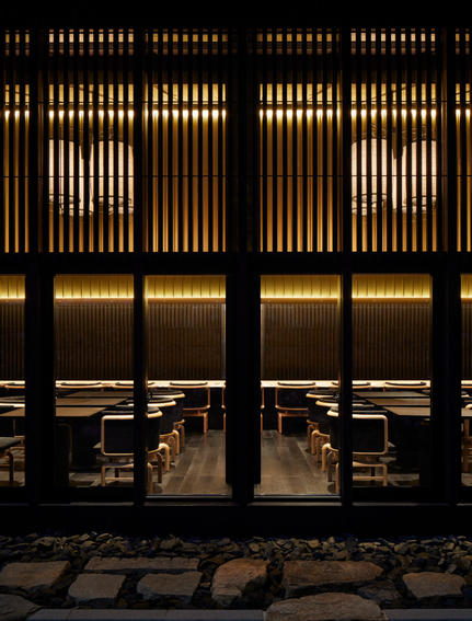 Taka-An exterior at dusk, illuminated wooden lattice doors and warm interior lighting, Aman Kyoto.