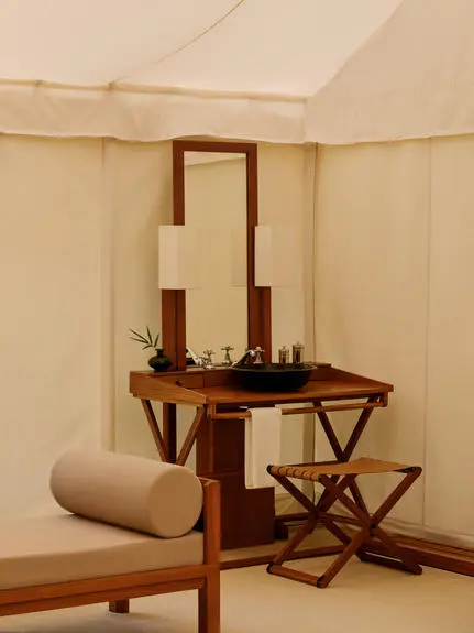 Bathroom vanity with mirror and wooden furnishings inside a tent at Aman-i-Khas.