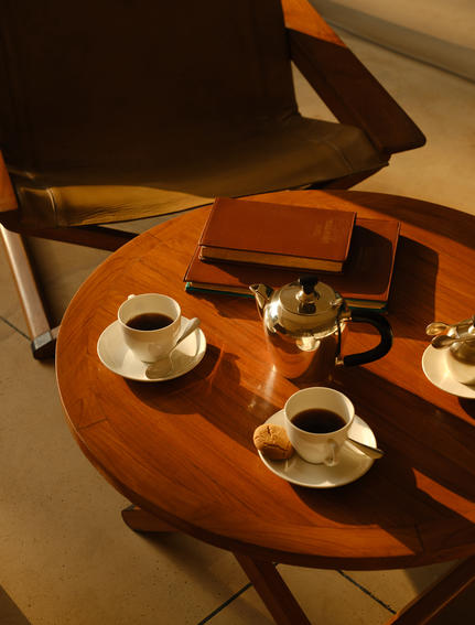 Overhead view of a wooden lounge tent table at Aman-i-Khas set with tea service and cushioned seating.