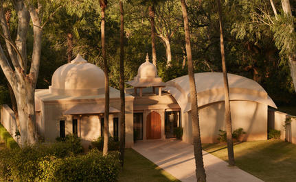 Pool pavilion at Amanbagh surrounded by trees at dusk, India.