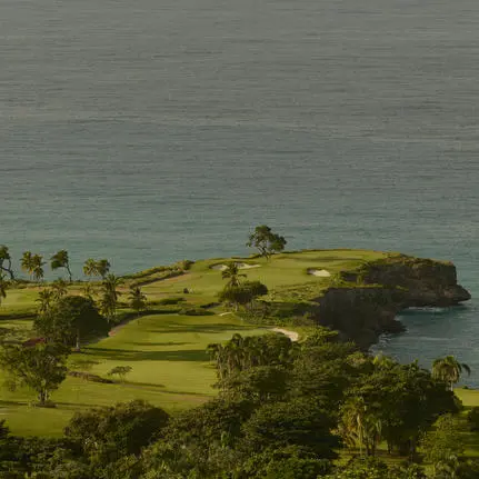 Península verde con palmeras y vegetación exuberante rodeada de aguas turquesas en Amanera, resort en República Dominicana.