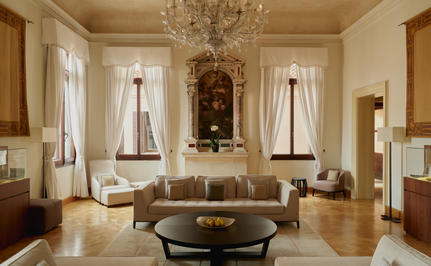 Living area in Coccina's apartment at Aman Venice, with elegant furnishings and tall windows overlooking the city.