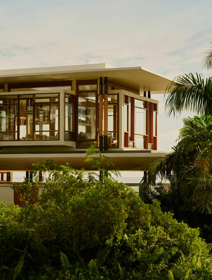 Exterior view of a raised Casa Grande residence at Amanera resort, with wooden architecture and tropical vegetation.