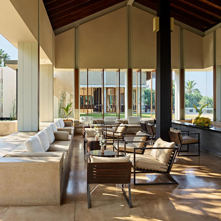 Amanwella interior lounge with high ceilings, floor-to-ceiling windows and natural daylight streaming across neutral furnishings.
