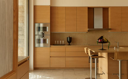 Four-bedroom villa kitchen with wooden cabinetry and marble countertop at Amanzoe.