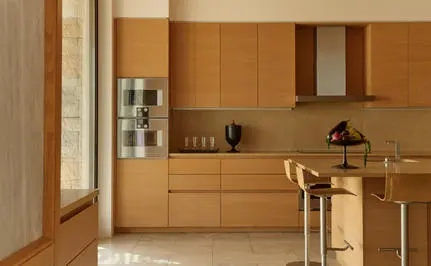 Four-bedroom villa kitchen with wooden cabinetry and marble countertop at Amanzoe.