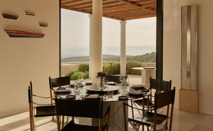 Four-bedroom villa dining area at Amanzoe with sea views and contemporary furnishings.