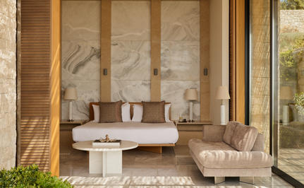 Spa pavilion at Amanzoe with neutral stone seating, sheer curtains, and natural light filtering through large windows.
