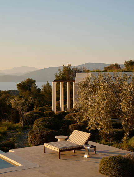 Villa terrace with loungers overlooking Aegean Sea at Amanzoe, Greece.