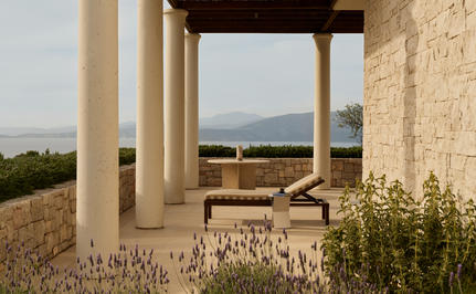 Villa terrace at Amanzoe with sea views and stone columns, overlooking the Peloponnese landscape.