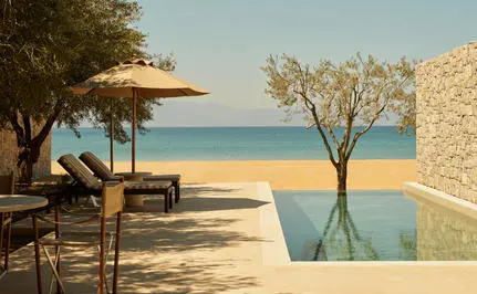 アマンゾイのビーチクラブカバナから海を眺める、プール、日除け、そして穏やかな海の景色。