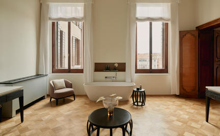 Marble bathroom at Aman Venice with twin basins, tall windows, and neutral tones.