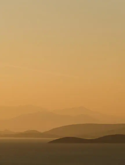 ギリシャのアマンゾイ・リゾートから見た、夕暮れ時の穏やかな海と島々の風景。