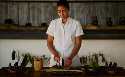 Terapeuta prepara ingredientes naturales en la cocina del spa de Amanera.